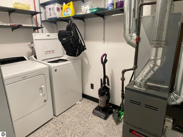 washroom featuring washing machine and dryer and heating unit