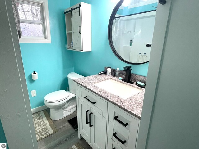 bathroom with vanity, a shower with curtain, hardwood / wood-style flooring, and toilet