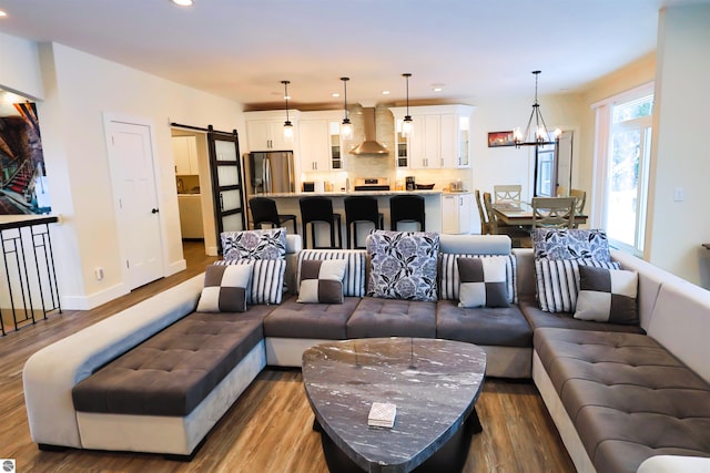 living room featuring a chandelier, a barn door, and hardwood / wood-style floors