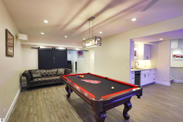 playroom featuring sink, a barn door, and light hardwood / wood-style floors