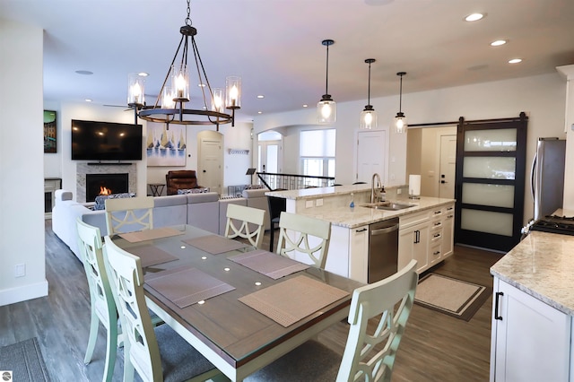 dining room with sink, a barn door, and dark hardwood / wood-style flooring