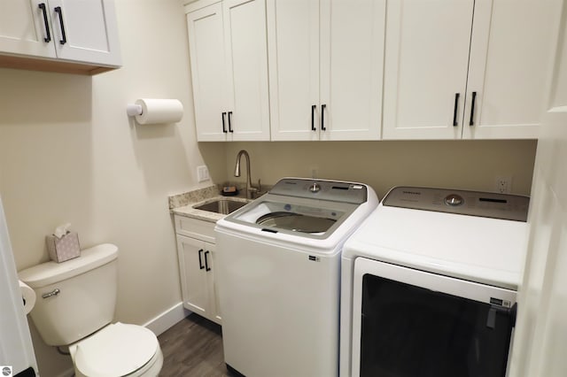 laundry room with sink, washing machine and dryer, and dark hardwood / wood-style flooring