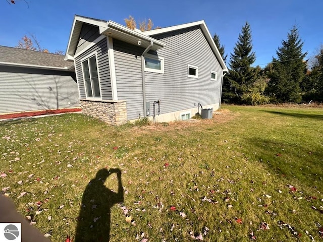 view of home's exterior with central air condition unit and a lawn