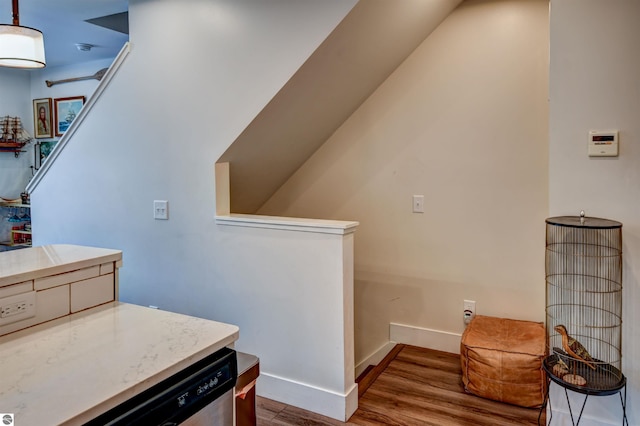 kitchen featuring dishwasher, hardwood / wood-style flooring, and decorative light fixtures