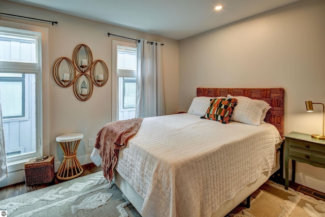 bedroom with hardwood / wood-style flooring and multiple windows