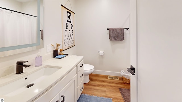 bathroom featuring vanity, toilet, and wood-type flooring