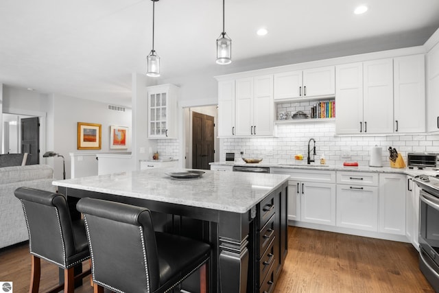 kitchen featuring a center island, white cabinets, sink, hanging light fixtures, and tasteful backsplash