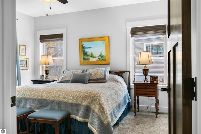 carpeted bedroom with ceiling fan and multiple windows