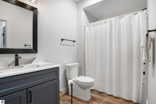 bathroom featuring toilet, vanity, a shower with shower curtain, and hardwood / wood-style flooring