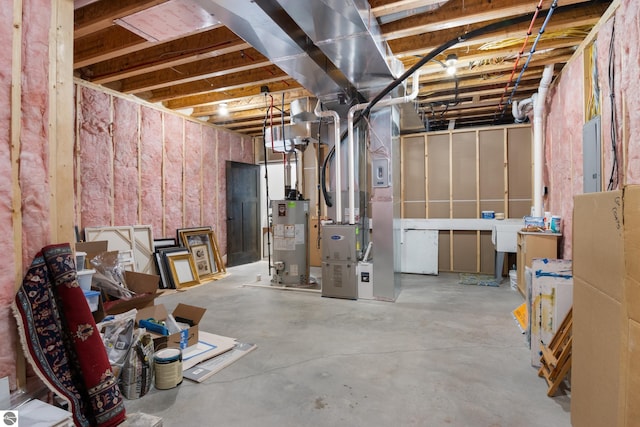 basement with gas water heater, electric panel, and heating unit