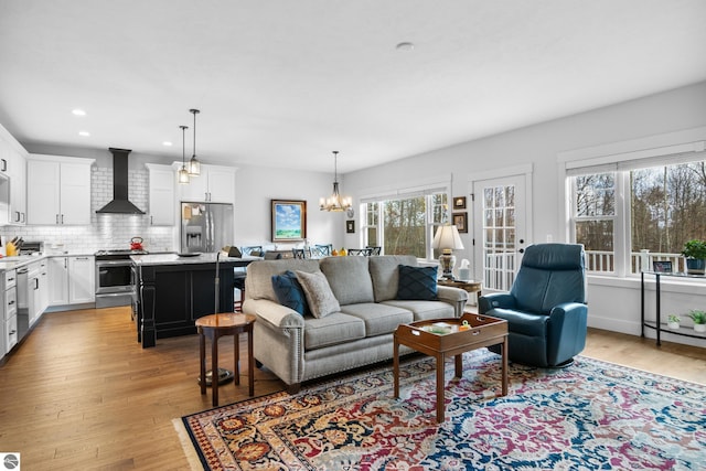 living room with light hardwood / wood-style floors and an inviting chandelier