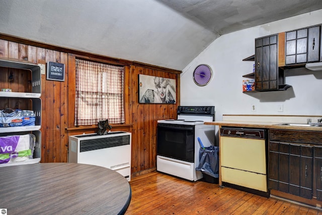 kitchen with vaulted ceiling, a textured ceiling, wooden walls, light hardwood / wood-style flooring, and white appliances