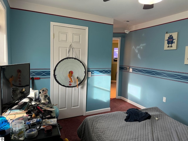 bedroom featuring ceiling fan and dark carpet