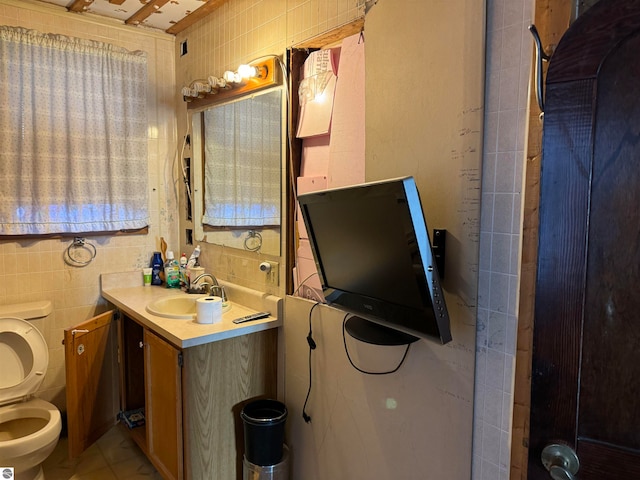 bathroom featuring tile walls, vanity, and toilet