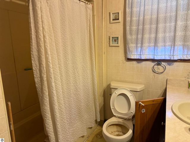 bathroom featuring tile walls, vanity, and toilet