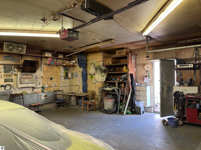 garage with a garage door opener and a workshop area