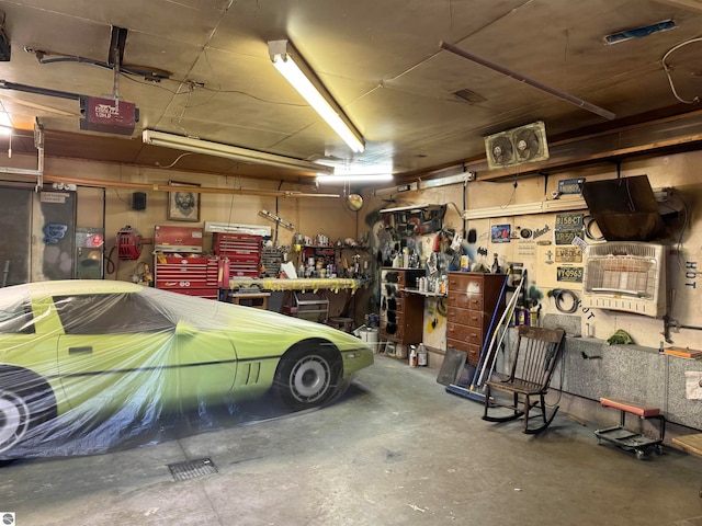 garage with a garage door opener and a workshop area