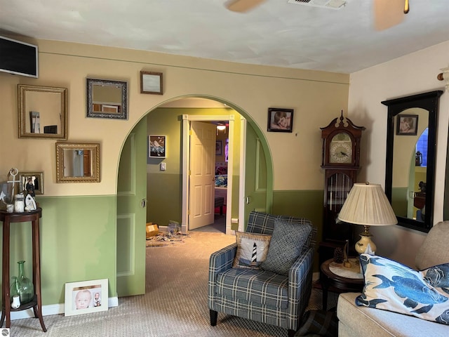 living area with carpet flooring and ceiling fan