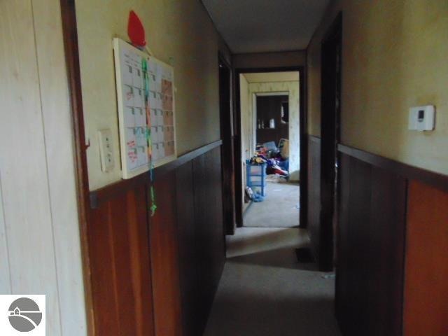 corridor featuring wood walls