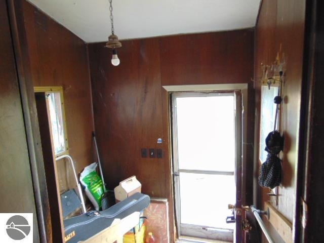 doorway featuring wooden walls