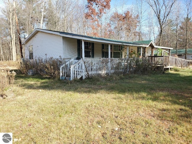 2824 Badger Rd, Beaverton, MI 48612 - manufactured / mobile home with a porch, a front lawn, and metal roof