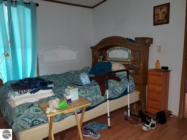 bedroom with ornamental molding and hardwood / wood-style flooring