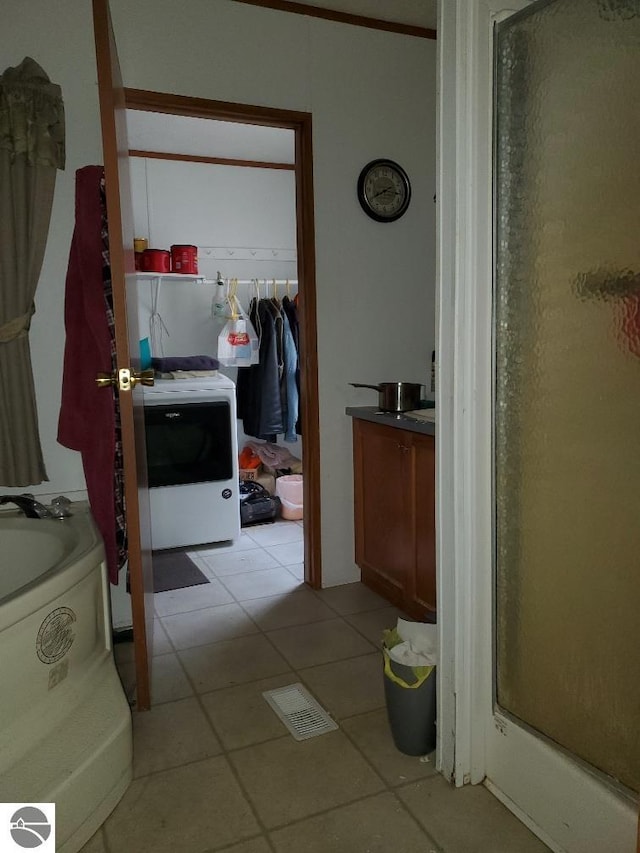 bathroom with tile patterned flooring, ornamental molding, washer / dryer, vanity, and separate shower and tub