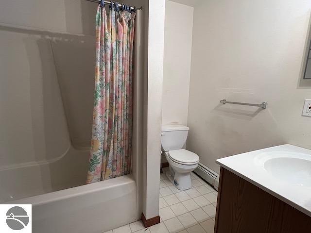 full bathroom featuring a baseboard heating unit, toilet, tile patterned floors, vanity, and shower / bath combination with curtain