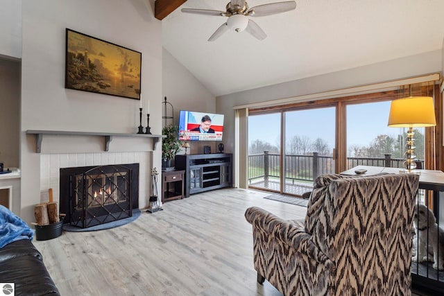 living room with a fireplace, lofted ceiling, ceiling fan, and wood-type flooring