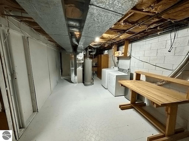 basement with heating unit, gas water heater, and washing machine and clothes dryer