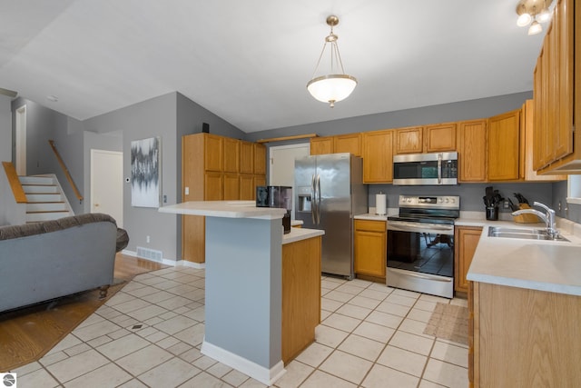 kitchen featuring light tile patterned floors, sink, decorative light fixtures, and appliances with stainless steel finishes