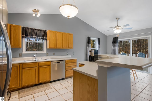 kitchen featuring sink, appliances with stainless steel finishes, vaulted ceiling, and an island with sink