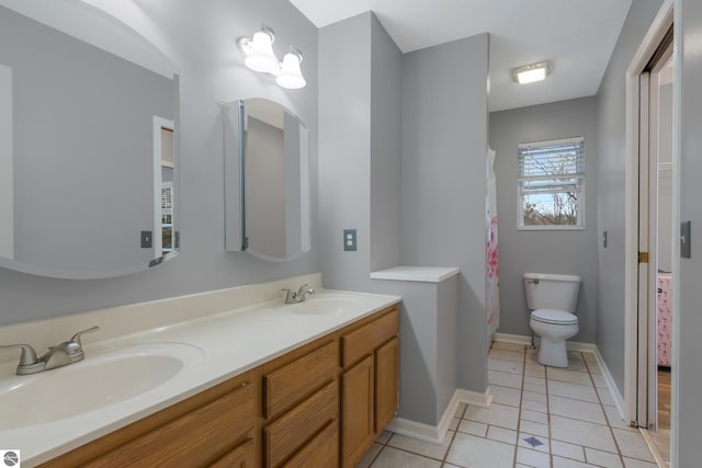 bathroom with tile patterned flooring, vanity, and toilet