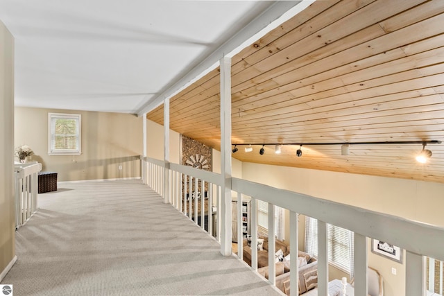 hallway with carpet, track lighting, wood ceiling, and vaulted ceiling