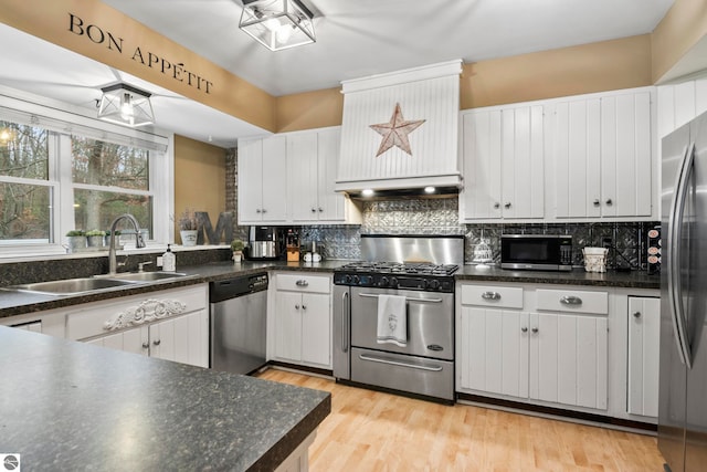 kitchen with backsplash, light wood-type flooring, stainless steel appliances, sink, and white cabinetry