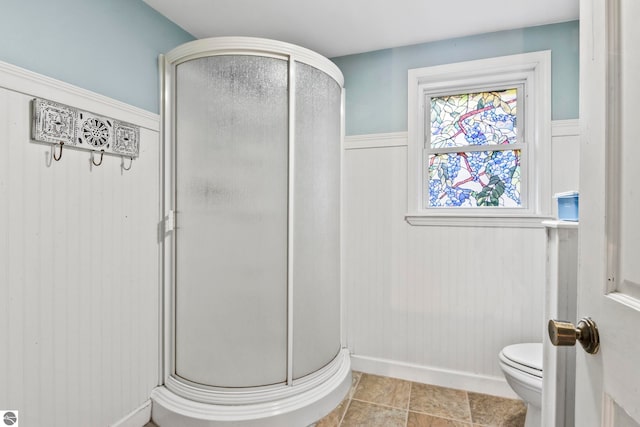 bathroom with a shower with shower door and toilet