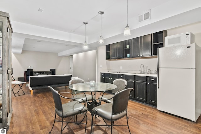 dining space featuring light wood-type flooring and sink