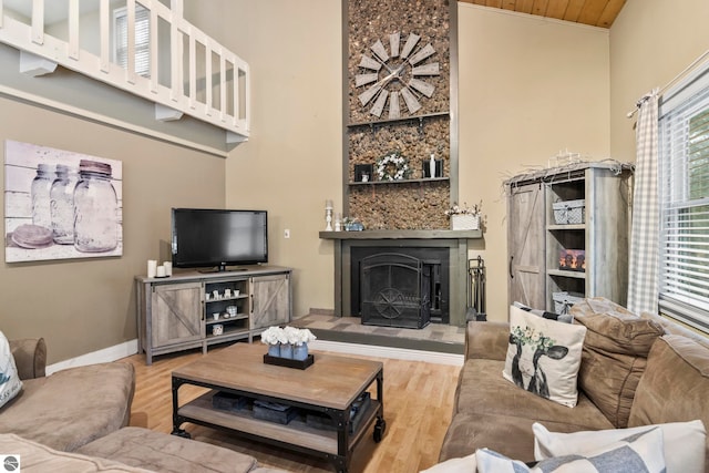 living room with wood-type flooring, a towering ceiling, and wood ceiling