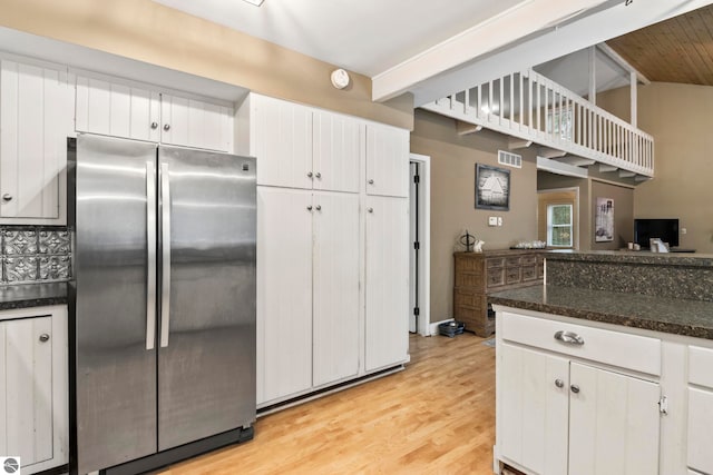 kitchen with stainless steel fridge, light hardwood / wood-style flooring, and white cabinetry