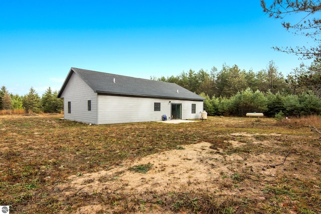 rear view of property featuring a lawn