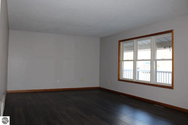 spare room with dark hardwood / wood-style flooring