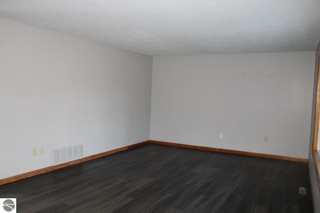 spare room with dark hardwood / wood-style flooring, lofted ceiling, and a textured ceiling