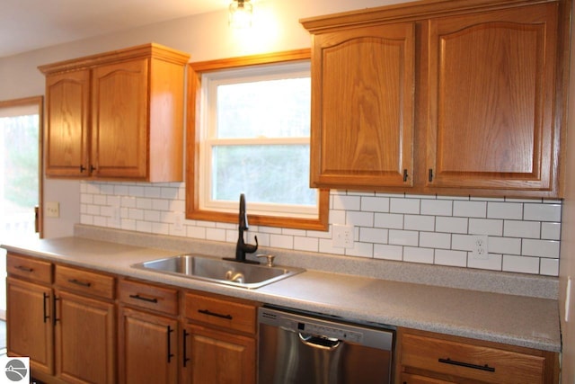 kitchen featuring dishwasher, a wealth of natural light, sink, and tasteful backsplash