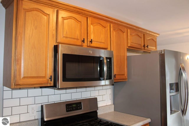 kitchen featuring stainless steel appliances and tasteful backsplash