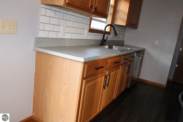 kitchen with dishwasher, sink, dark hardwood / wood-style floors, and backsplash