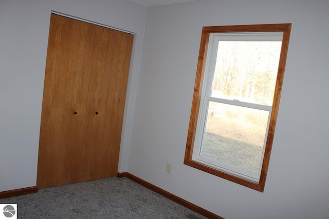 unfurnished bedroom featuring carpet, multiple windows, and a closet