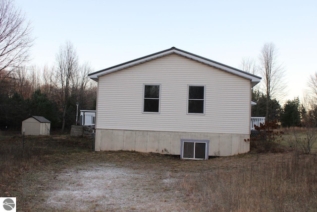 property exterior at dusk featuring a storage unit