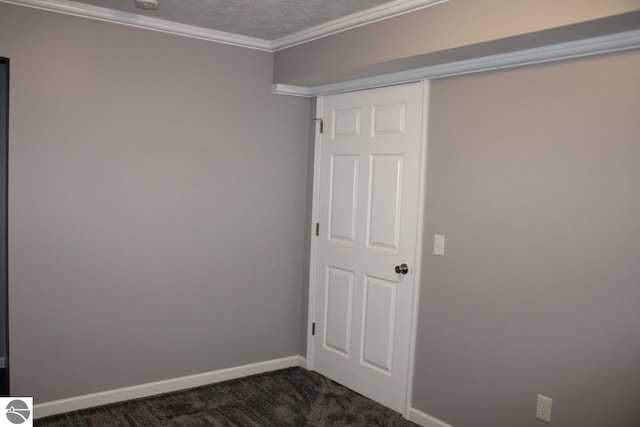 carpeted empty room featuring a textured ceiling and crown molding