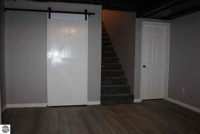 staircase featuring a barn door and hardwood / wood-style flooring