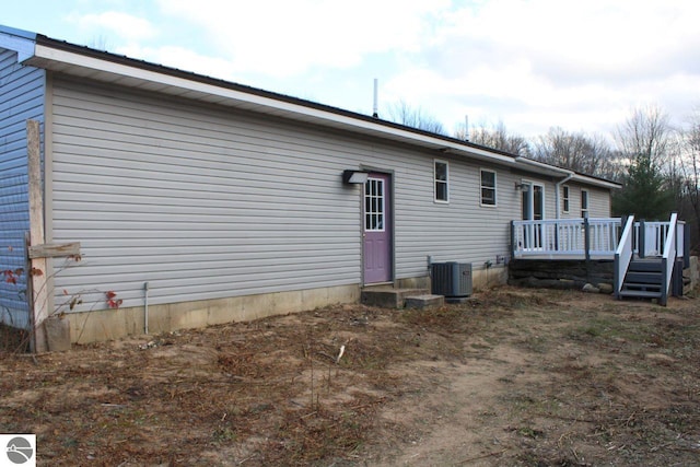 view of side of property with a deck and central AC unit